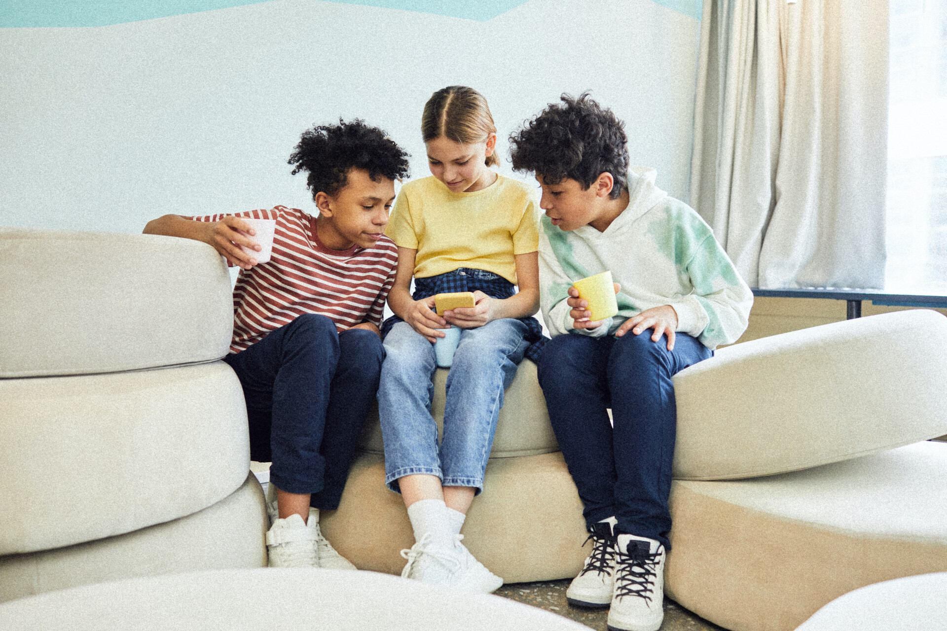 Bilde av tre barn som ser på mobil som illustrerer TV og YouTube som tjeneste.